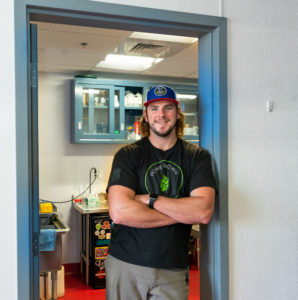 Matt Allen, Quality Control Manager of Bent Water Brewing Co., stands in the doorway of the lab where he analyzes the beer produced.